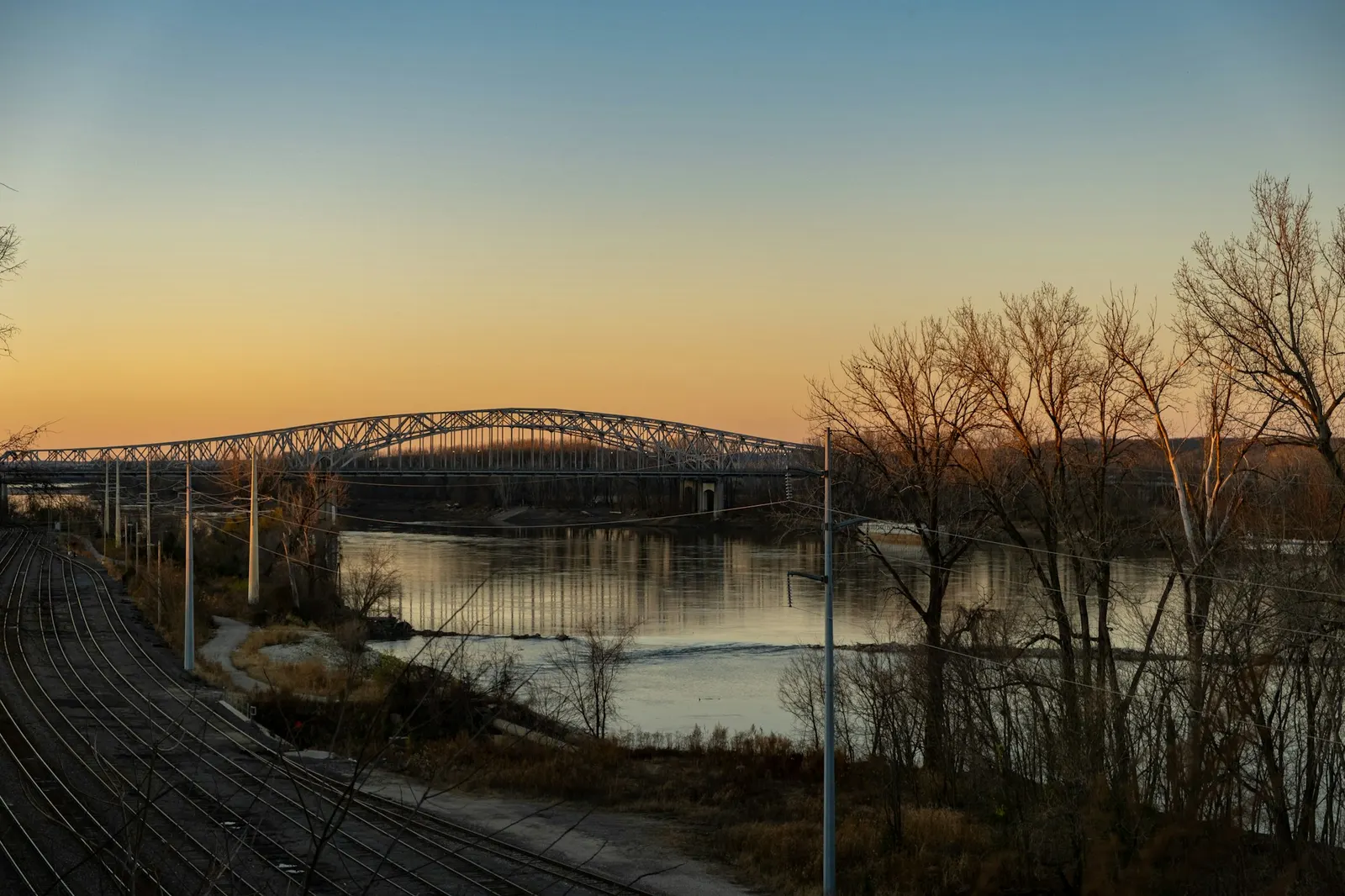 Steel bridge over the river at sunset