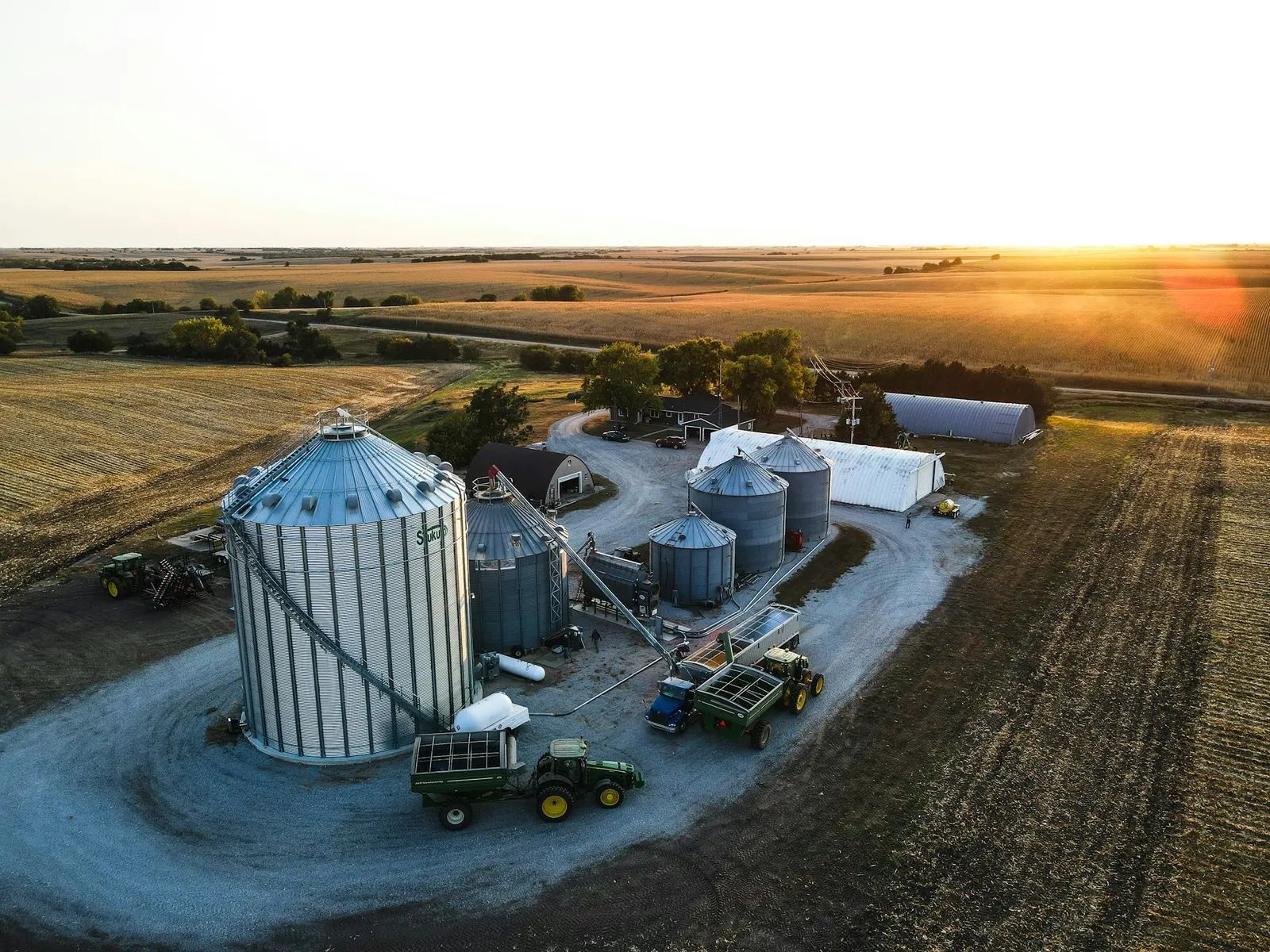 Farmstead and grain bins at sunset