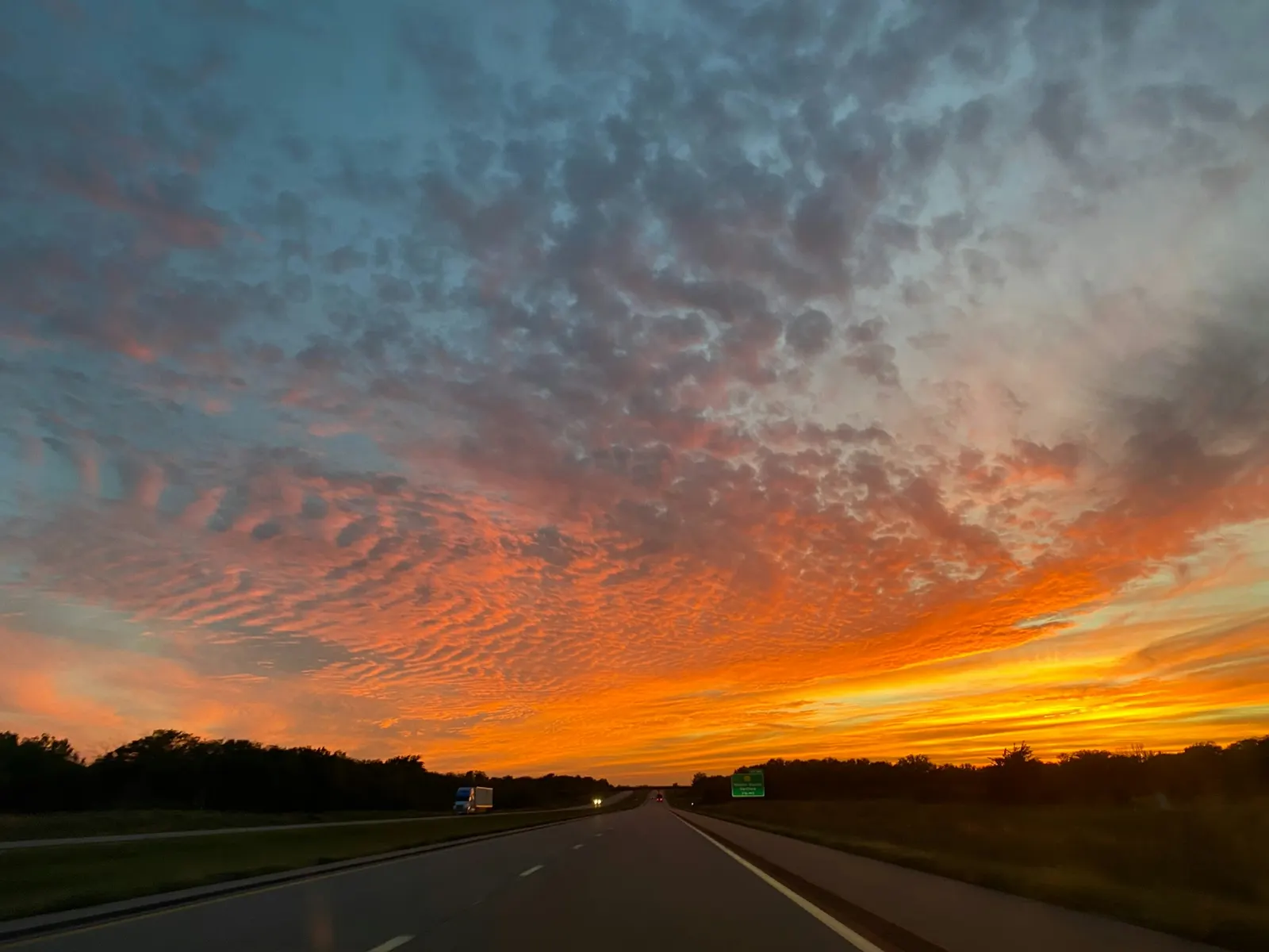 Car driving down a highway at sunset