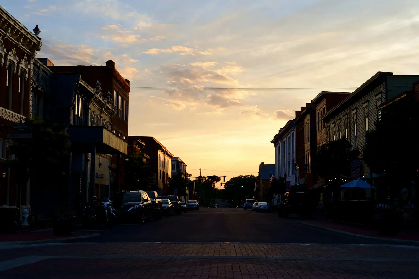 Brick storefronts on a small-town main street at sunset